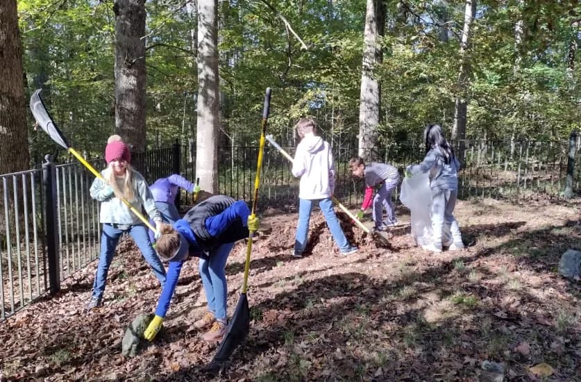 Students rake leaves during a community service project