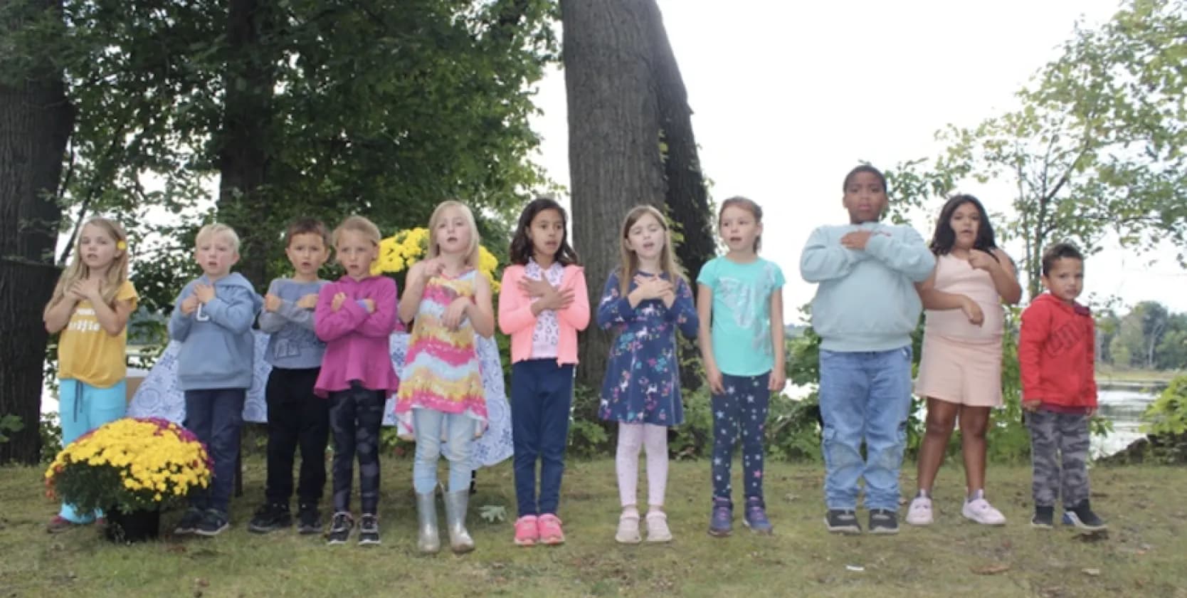Kindergarten students sing together outdoors