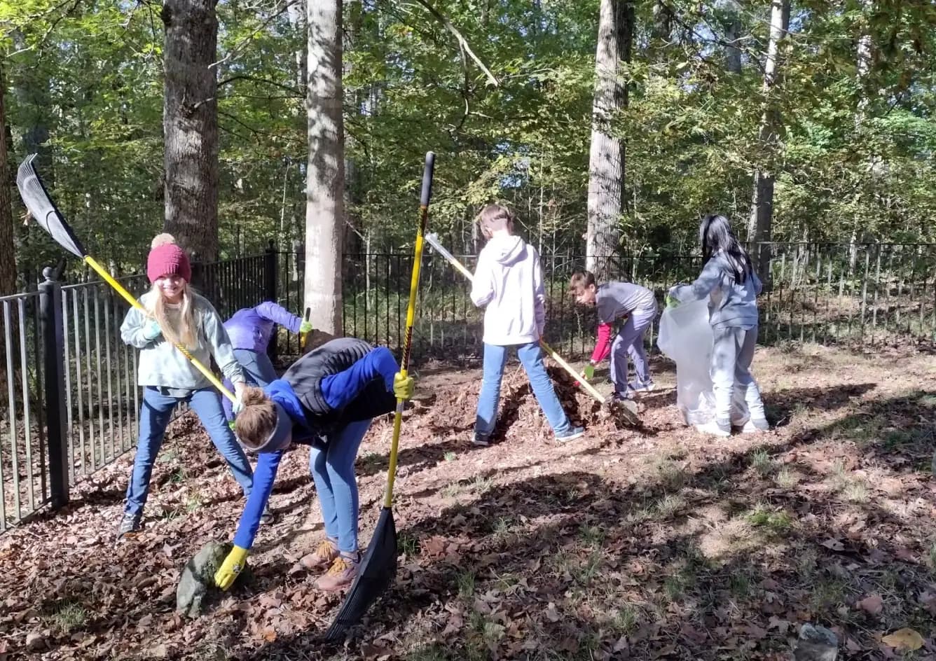 Students rake leaves during a community service project