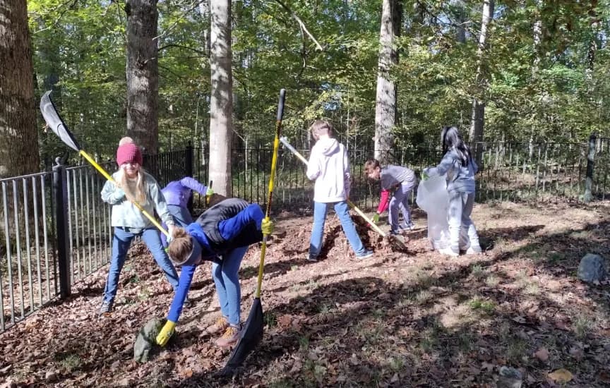 Students rake leaves during a community service project