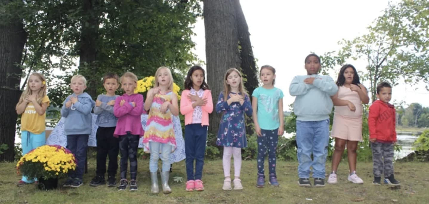 Kindergarten students sing together outdoors