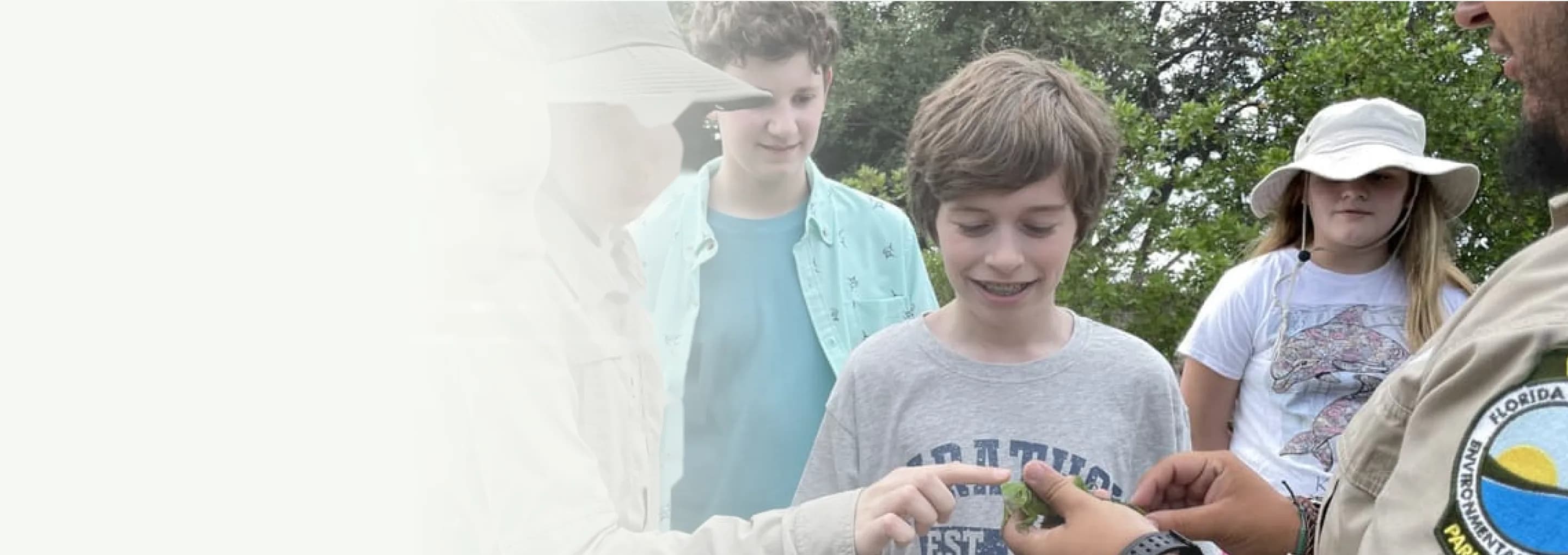 Students examine a plant with a park ranger on a class trip to Florida