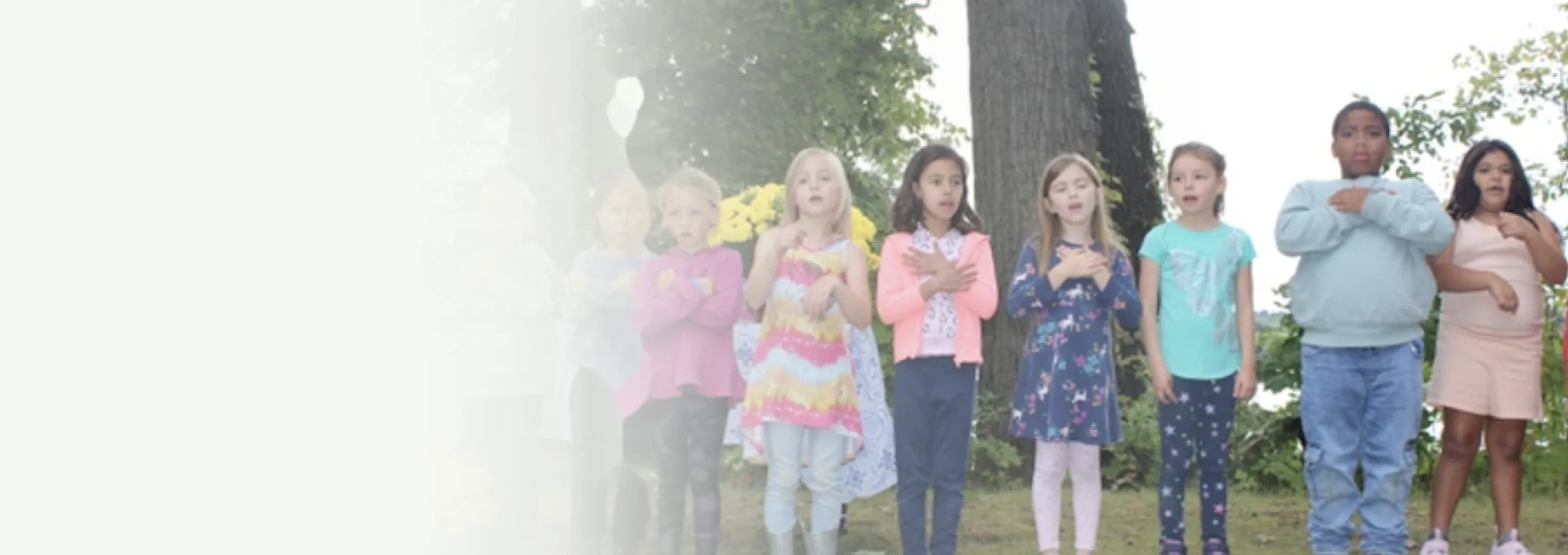 Kindergarten students sing together outdoors